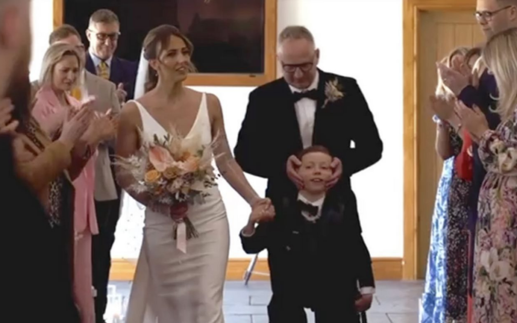 Un niño logra caminar con su madre al altar gracias a un arnés especial